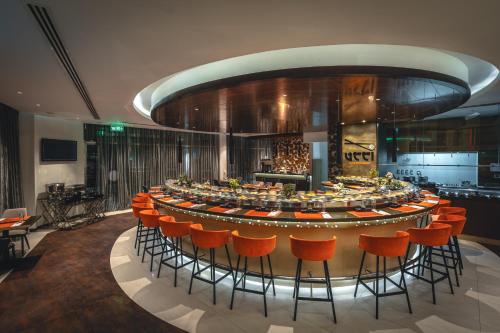 a large round table with orange chairs in a room at Ramada by Wyndham Dubai Barsha Heights in Dubai