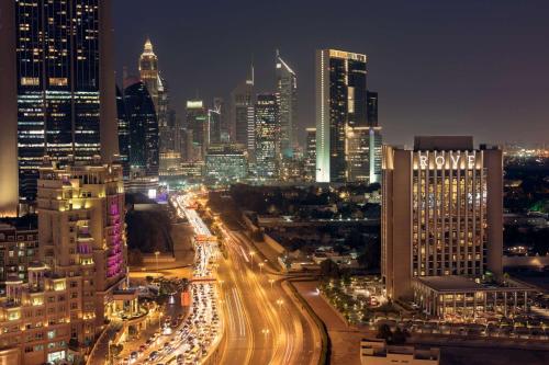 a city lit up at night with traffic at Rove Downtown in Dubai