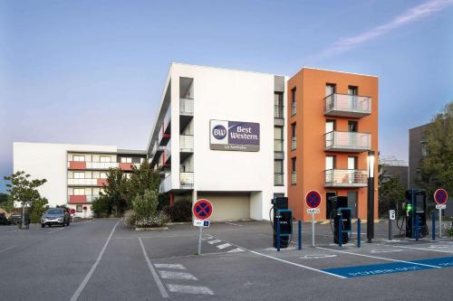 an empty parking lot in front of a building at Best Western Les Aureliades Saint Nazaire in Trignac