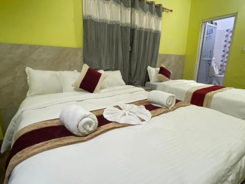 two beds in a hotel room with towels on them at Hotel Kavya Inn in Bharatpur