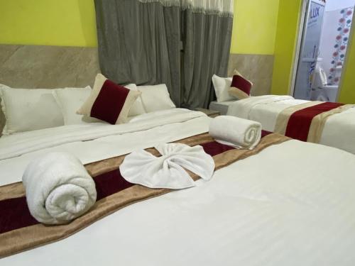 Hotel Kavya Inn في بهاراتبور: سريرين في غرفة الفندق عليها مناشف