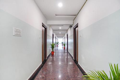 an empty corridor of a building with plants at FabHotel Sri Karthikeya Grand - Nr Nexus Mall, Kukatpally in Hyderabad