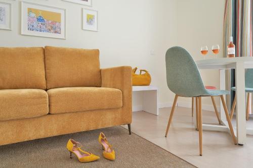 Blume Cruz Suites في مدريد: غرفة معيشة مع أريكة وكرسي وأحذية