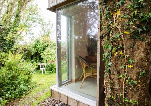 a glass window on the side of a house at Y Caban - Cosy Cabin in Pembrokeshire in Saint Dogmaels