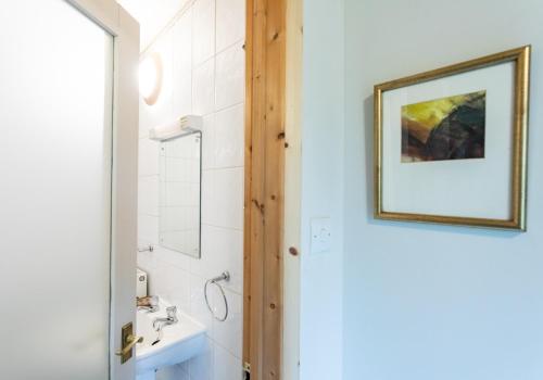 a bathroom with a sink and a picture on the wall at Y Caban - Cosy Cabin in Pembrokeshire in Saint Dogmaels