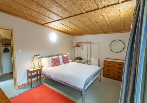 a bedroom with a bed and a wooden ceiling at Y Caban - Cosy Cabin in Pembrokeshire in Saint Dogmaels