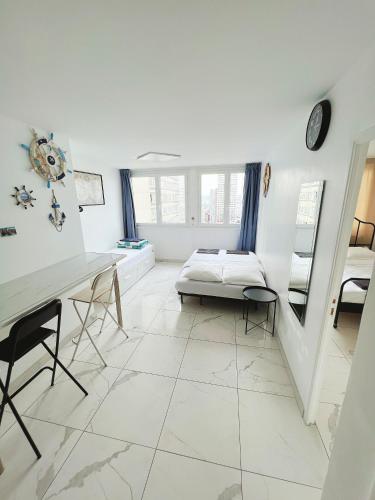 Apartment near subway and supermarket في باريس: غرفة بيضاء مع سرير ومكتب