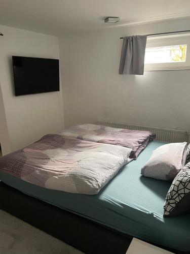 - un lit dans une pièce avec une télévision dans l'établissement Appartment Schmidtner, à Ansbach