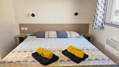- une chambre avec un lit et des serviettes jaunes dans l'établissement Grand mobil-home n°604 3ch tout confort au calme, à Gastes