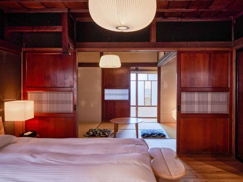 a bedroom with a bed and a table at NIPPONIA Sawara Merchant Town Hotel in Katori