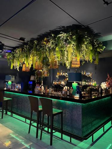 a bar with chairs and plants hanging from the ceiling at Royal Phuket City Hotel in Phuket Town