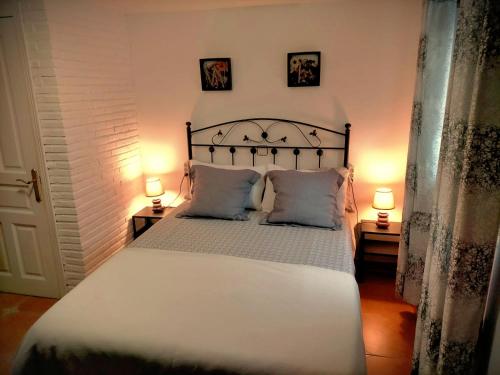 sypialnia z dużym białym łóżkiem z 2 lampami w obiekcie Casa Rural La Peña en Unquera (Cantabria) w mieście Unquera