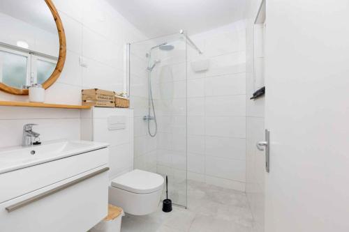 a white bathroom with a toilet and a shower at Holiday home in Vrbnik/Insel Krk 36717 in Vrbnik