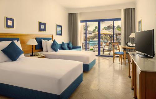 a hotel room with two beds and a television at Jaz Fayrouz in Sharm El Sheikh