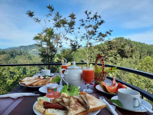 a table with plates of food and drinks on a balcony at Nine Arch Gap in Ella