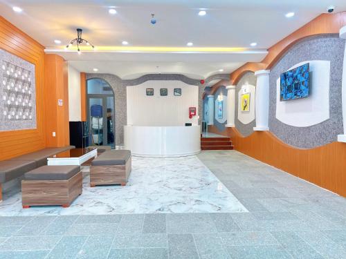 a lobby with orange walls and a waiting area with benches at Milanesa Hotel and Apartment in Vung Tau