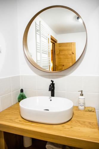 a bathroom with a white sink and a mirror at Pension Sólyomkő in Bixad