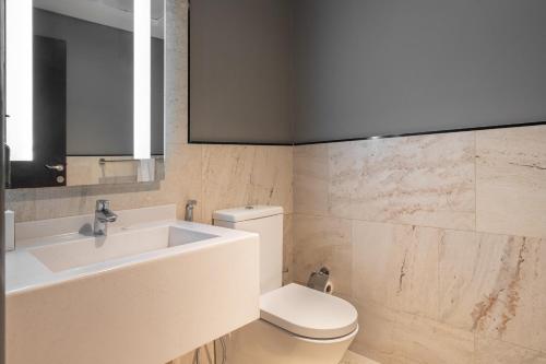 a bathroom with a sink and a toilet at Ramada by Wyndham Dubai Barsha Heights in Dubai