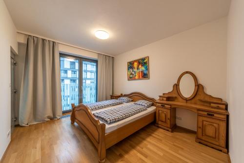 a bedroom with a bed and a dresser and a mirror at Garden Towers Apartments in Prague