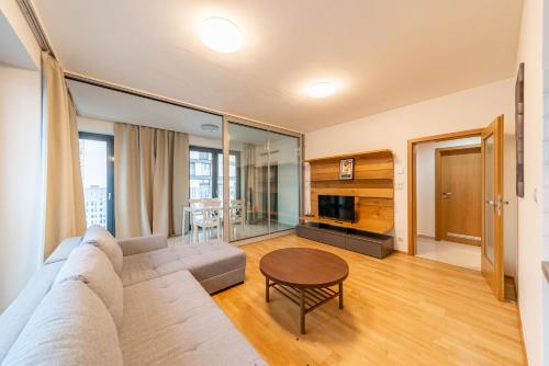 - un salon avec un canapé et une table dans l'établissement Garden Towers Apartments, à Prague