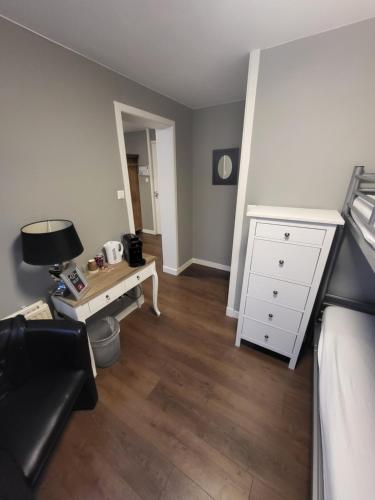 a living room with a desk and a white dresser at Hotel Broer & Zus in The Hague