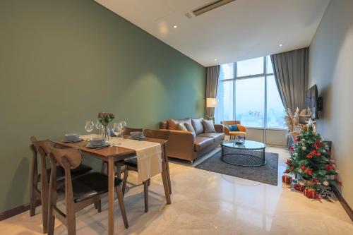 uma sala de estar com uma mesa e uma árvore de Natal em Calm Sojourn, Sky Suites KLCC em Kuala Lumpur