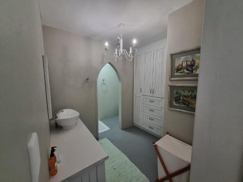 a bathroom with a sink and a chandelier at Manatoka Unit 1 in Jacobs Bay