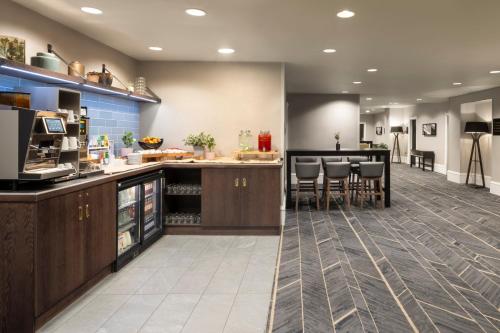 a kitchen with a counter and a bar with stools at Crowne Plaza Leeds by IHG in Leeds