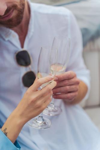 a man holding two glasses of white wine at Hôtel Expérience - Quartier Des Marinas in Magog-Orford