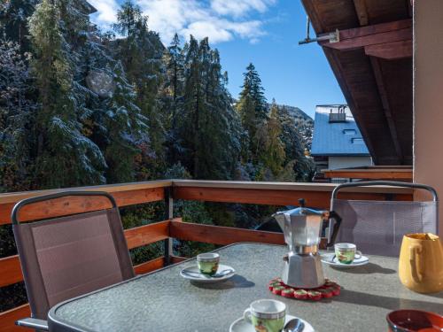 d'un balcon avec une table et une cafetière. dans l'établissement Apartment Derborence 25 by Interhome, à Nendaz