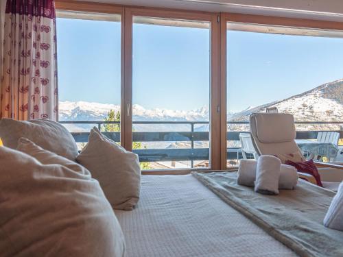 a bedroom with a bed and a large window at Apartment Panoramic B1 by Interhome in Nendaz