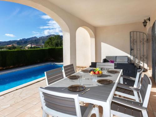 a dining room with a table and chairs and a pool at Villa Aguamarina by Interhome in Miami Platja