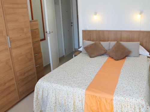 a bedroom with a bed with a wooden headboard at Apartment Turia Playa by Interhome in Benidorm