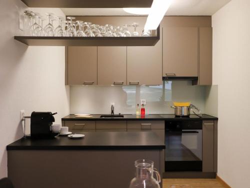a kitchen with a counter with glasses on a shelf at Apartment Allod-Park-15 by Interhome in Davos