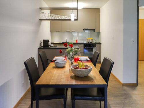a dining room table with bowls of fruit and flowers on it at Apartment Allod Park Haus C U04 by Interhome in Davos