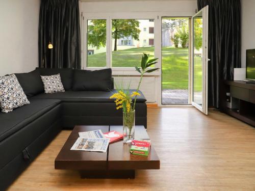 a living room with a black couch and a coffee table at Apartment Allod Park Haus C U04 by Interhome in Davos