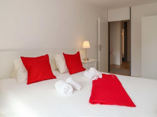 una camera da letto con cuscini rossi e bianchi su un letto di Apartment Allod-Park-43 by Interhome a Davos