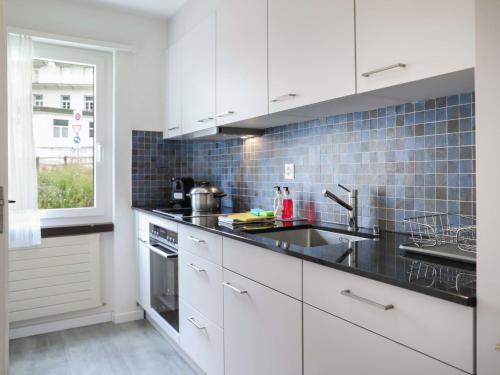 a kitchen with white cabinets and a sink at Apartment Allod-Park-43 by Interhome in Davos