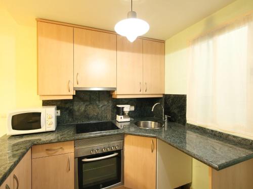 cocina con fregadero y microondas en Apartment Sidney by Interhome, en Cala de Finestrat