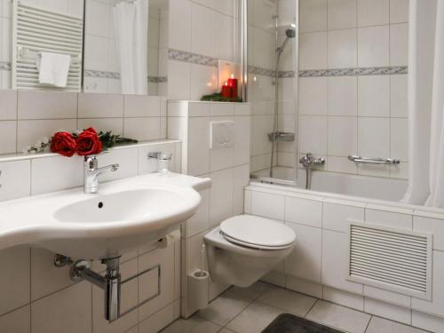 Apartment Allod Park Haus B E01 by Interhome في دافوس: حمام مع حوض ومرحاض وحوض استحمام