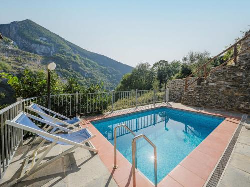 una piscina con 2 sillas y una montaña en Holiday Home L'Aia by Interhome, en Seravezza