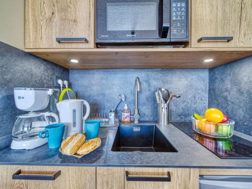 un comptoir de cuisine avec un évier et un micro-ondes dans l'établissement Apartment Arcelle 604 by Interhome, à Val Thorens