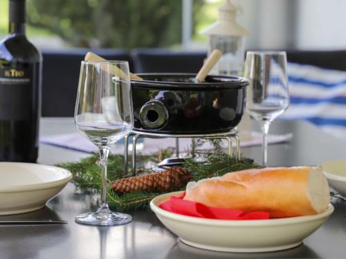 a table with two wine glasses and a bowl of food at Apartment Mon Repos by Interhome in Davos