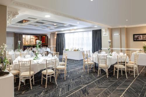 a banquet room with white tables and chairs at Crowne Plaza Leeds by IHG in Leeds
