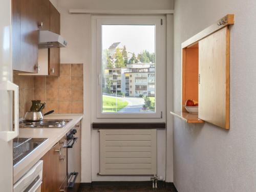 Apartment Allod-Park-48 by Interhome في دافوس: مطبخ مع نافذة ومغسلة وموقد
