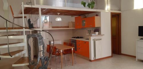 a kitchen with orange cabinets and a table and chairs at Termini Loft in Rome