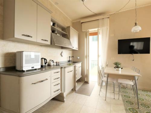 a kitchen with white cabinets and a table with a microwave at Apartment Agave by Interhome in Civitella Marittima