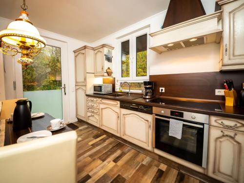 a kitchen with white cabinets and a stove top oven at Chalet Haus am Fluss by Interhome in Wahmbeck