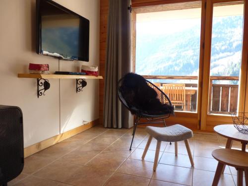 sala de estar con silla y ventana grande en Apartment Les Chalets de Marie A 22 by Interhome en Ovronnaz