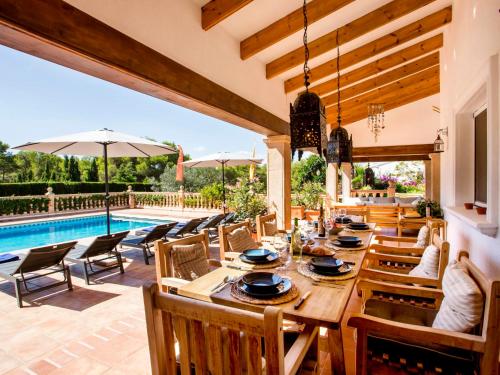 een patio met een tafel en stoelen en een zwembad bij Villa Lantana by Interhome in Jávea